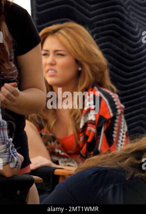 Miley Cyrus looks pensive as she takes a break on the set of her new film 'So Undercover.' The new movie, due in theaters next year, also stars Kelly Osbourne. New Orleans, LA. 12/16/10. Stock Photo