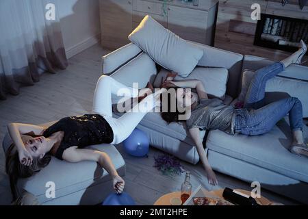 Drunk women sleeping in messy room after party Stock Photo