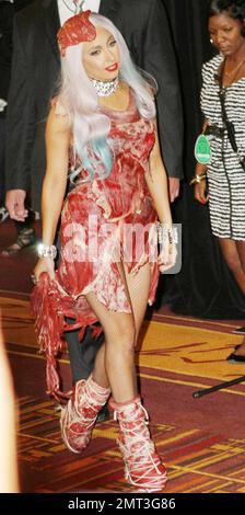 Lady Gaga adorned in her meat dress, boots and hat, backstage in the  pressroom after the
