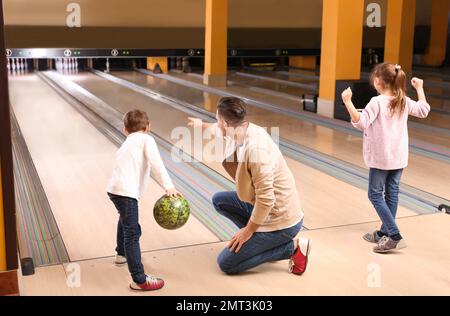 Happy family spending time together in bowling club Stock Photo