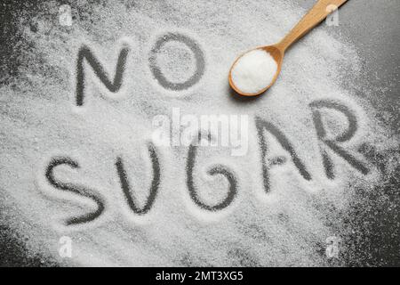 Flat lay composition with phrase NO SUGAR and spoon on grey table Stock Photo