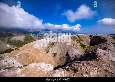 High alpine landscape with craters, mountains and ridges of the French Dauphiné Alps in the distance, seen from the pass Col du Galibier. Stock Photo