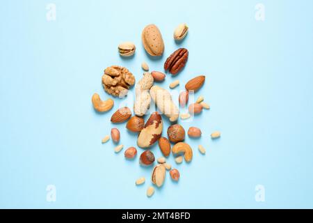 Flat lay composition with different nuts on light blue background Stock Photo
