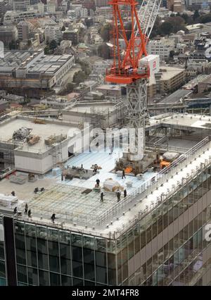 Construction workers working on the roof of a new skyscraper in Shibuya, Tokyo, Japan.