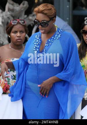 Reality TV star NeNe Leakes (blue bathing suit cover) from the Bravo series 'The Real Housewives of Atlanta' lounges poolside with friends.  The group chat, read magazines and tan while at their hotel. Miami, FL. 09/04/10. Stock Photo