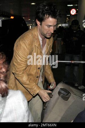 'ER' star Noah Wylie and family arrive stateside at Los Angeles International Airport after a family European vacation. Noah and his wife Tracy Warbin, carried thier children, daughter Auden and son Owen Strausser through the airport as they were assisted with their luggage. The kids looked tired after the long flight. Los Angeles, CA. 4/29/09.   . Stock Photo