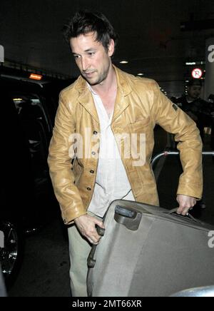 'ER' star Noah Wylie and family arrive stateside at Los Angeles International Airport after a family European vacation. Noah and his wife Tracy Warbin, carried thier children, daughter Auden and son Owen Strausser through the airport as they were assisted with their luggage. The kids looked tired after the long flight. Los Angeles, CA. 4/29/09.   . Stock Photo