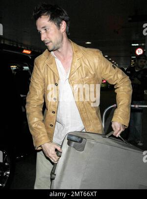 'ER' star Noah Wylie and family arrive stateside at Los Angeles International Airport after a family European vacation. Noah and his wife Tracy Warbin, carried thier children, daughter Auden and son Owen Strausser through the airport as they were assisted with their luggage. The kids looked tired after the long flight. Los Angeles, CA. 4/29/09.   . Stock Photo