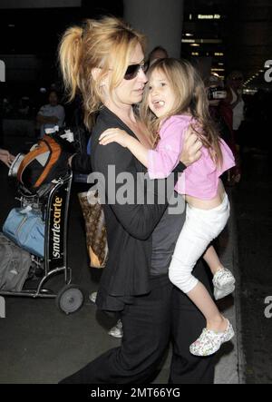 'ER' star Noah Wylie and family arrive stateside at Los Angeles International Airport after a family European vacation. Noah and his wife Tracy Warbin, carried thier children, daughter Auden and son Owen Strausser through the airport as they were assisted with their luggage. The kids looked tired after the long flight. Los Angeles, CA. 4/29/09.   . Stock Photo