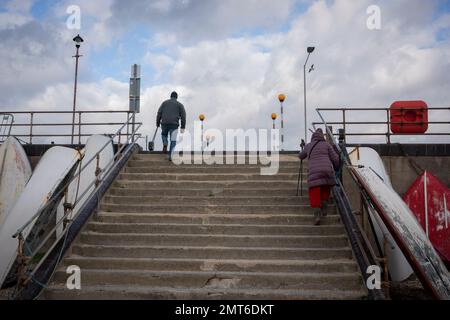 On the third anniversary of the UK leaving the European Union (EU), a couple climb steps on the beach at Southend-on-Sea, on 31st January 2023, in Southend, England. In the 2016 EU Referendum, 39,348 voters  in Southend-on-Sea voted to Remain (41.9%) and 54,522 (58.1%) to Leave. The UK officially left the EU on 31st January 2020. Stock Photo