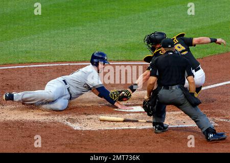 Milwaukee Brewers' Travis Shaw, center, slides safely under the swipe tag  by Pittsburgh Pirates catcher Francisco Cervelli, right, with umpire Mike  Winters watching the play, in the fourth inning of a baseball