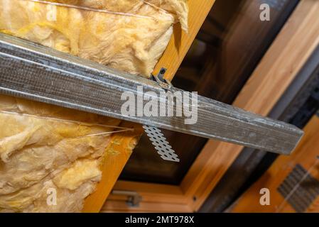 Aluminum frame with hangers placed on beams in the attic for mounting plasterboards. Stock Photo