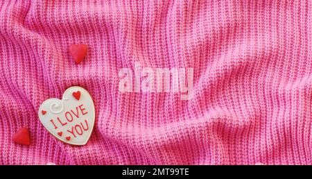 Valentines Day Background. Handmade cookies on a pink Textile. Fabric folds. Top View Stock Photo