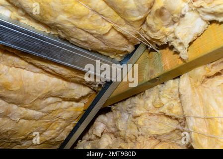 Aluminum frame with hangers placed on beams in the attic for mounting plasterboards. Stock Photo