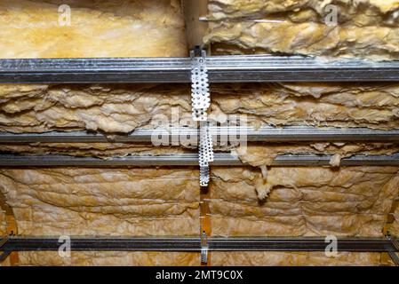 Aluminum frame with hangers placed on beams in the attic for mounting plasterboards. Stock Photo