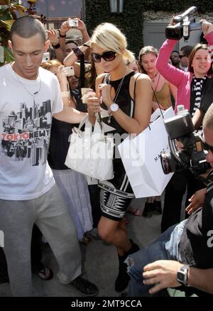 Paris Hilton primps herself during a shopping trip to Diane von Furstenberg's boutique. She sprayed herself with perfume, touched up her lipstick and spent a while checking out her reflection in the mirror. Paris also paid a visit to Marc Jacobs and Fred Segal. Paris was carrying one of her own handbags emblazoned with her name. Los Angeles, Ca. 3/13/08. Stock Photo