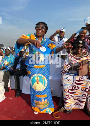 01 February 2023, Democratic Republic of the Congo, Kinshasa: A woman dances at the N'Dolo military airfield before the start of Pope Francis' mass wearing a dress with the pontiff's portrait. At a large Mass in Kinshasa attended by more than a million people, Pope Francis prayed for an end to violence on the African continent. He encouraged people to be 'missionaries of peace' and to 'work together with everyone to break the cycle of violence and shatter the intrigues of hatred.' He said this during his homily Wednesday in the capital of the Democratic Republic of Congo. Photo: Manuel Schwarz Stock Photo