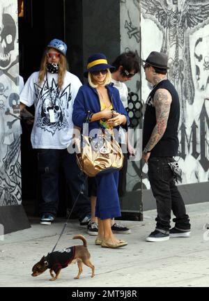 One of these things is not like the others! Paris Hilton, with her little dog in tow, looks a bit out of place with her colorful outfit and big blue hat as she and boyfriend Benji Madden make a stop for some shopping at Benji's store, DCMA Collective. Hollywood, CA. 5/20/08. Stock Photo