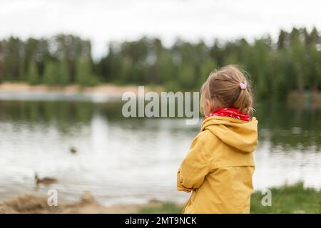 Little girl jumping on trampoline and going down the slide Stock Photo