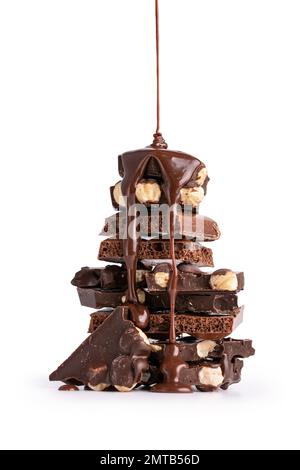 Pieces of broken tasty milk, dark and air chocolate bars with hazelnut and flowing hot chocolate isolated on white background Stock Photo