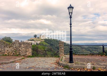 photo of picturesque street with street lamp. iron gate with view of medieval castle on hill. Stock Photo