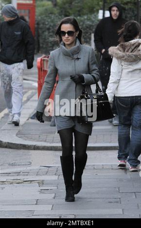 Pippa Middleton was seen walking to work in South Kensington and attempting to keep warm in a grey coat, grey skirt and accessorized with black leather gloves, black purse, black leggings, black knee high boots and large black sunglasses. London, UK. 7th December 2011. Stock Photo