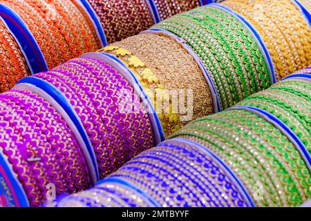 Multi-colored designer lace ribbon on the shelf. Lace tape shop. Textile shop. Stock Photo