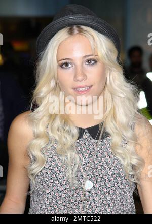 UK singer Pixie Lott shows off her tanned and slightly freckled face as she arrives at Heathrow from LA where she was working on a new album and also attending events including the 2011 Nickelodeon Kids' Choice Awards.  Wearing a trendy fedora with a feather in it, a patterned top paired with striped high-waist short shorts and brown lace-up shoes, Pixie looked happy to be home as she made her way through the airport pushing all her own luggage on a trolly. London, UK. 04/04/11. Stock Photo