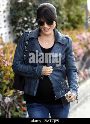 Clutching her leather jacket around her baby bump Selma Blair