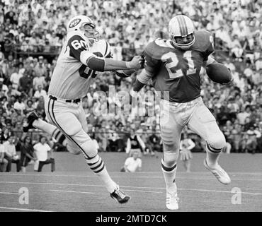 Miami Dolphin back Jim Kiick (21) seems totally unaware that he is about to  be trounced by New York Jets John Elliott (80) during action in their AFL  game Sunday afternoon Dec.