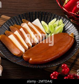 Delicious fresh mullet roe with white radish slices and garlic sprout for Chinese lunar new year gift basket box, holiday celebration. Stock Photo