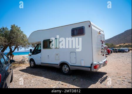 Motorhome is parked in public parking on the street in Crete, Greece. Campervan or motorhome is parked on the parking place on a public beach, Crete, Stock Photo