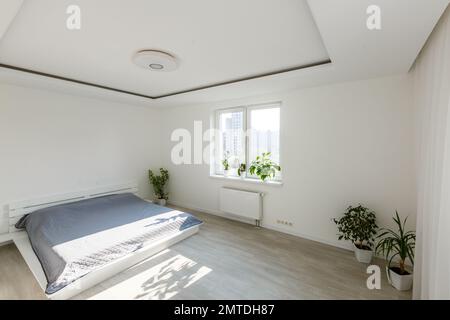 White bedroom with brick elements, balcony, double bed, desk Stock Photo