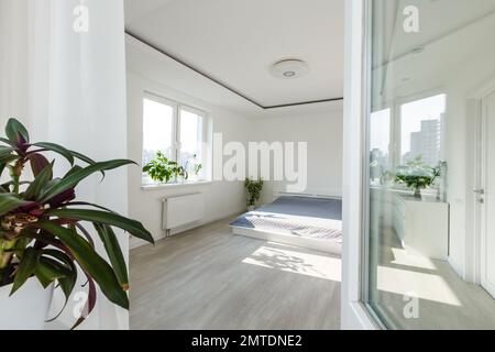 White bedroom with brick elements, balcony, double bed, desk Stock Photo