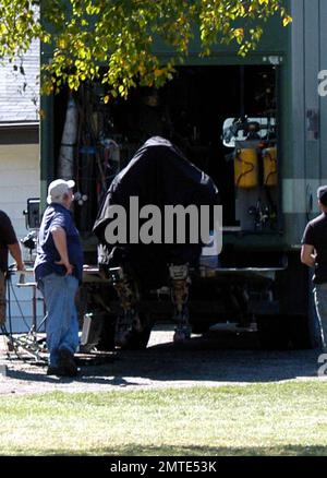 EXCLUSIVE!! Hugh Jackman discusses a scene on the set of his new film, 'Real Steel,' which is due out in 2011. The film is a boxing drama in which 2,000-pound robots that look like humans do battle. One of the robots featured in the film can be seen sitting on the back of a truck before being covered up by crew members as a youngster sitting on top of the truck looks down at what's going on. Detroit, MI. 9/15/10. Stock Photo