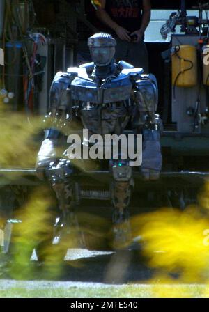 EXCLUSIVE!! Hugh Jackman discusses a scene on the set of his new film, 'Real Steel,' which is due out in 2011. The film is a boxing drama in which 2,000-pound robots that look like humans do battle. One of the robots featured in the film can be seen sitting on the back of a truck before being covered up by crew members as a youngster sitting on top of the truck looks down at what's going on. Detroit, MI. 9/15/10. Stock Photo