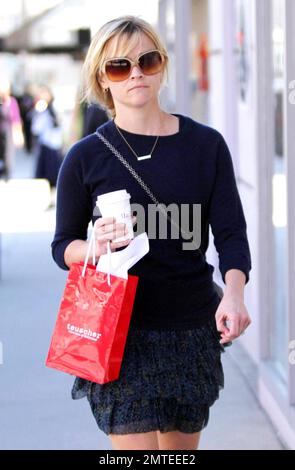 On a nice sunny afternoon actress Reese Witherspoon, in a lovely tiered floral patterned skirt, sweater and unique rectangle detailed necklace, stepped out to pick up a coffee and some Swiss chocolates from the chocolatier Teuscher. Witherspoon's latest film 'Water for Elephants' co-starring Robert Pattinson will premiere next month. Los Angeles, CA. 03/08/11. Stock Photo