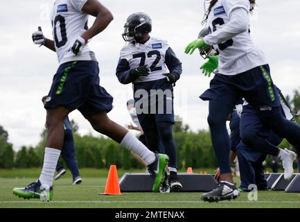 Michael Bennett (72) of the Seattle Seahawks loses his helmet as he tackles  Eddie Lacy (27) of the Green Bay Packers in the NFC Championship game at  CenturyLink Field in Seattle, Washington