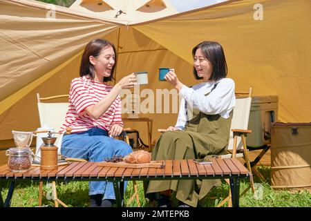 Young Japanese women at campsite Stock Photo