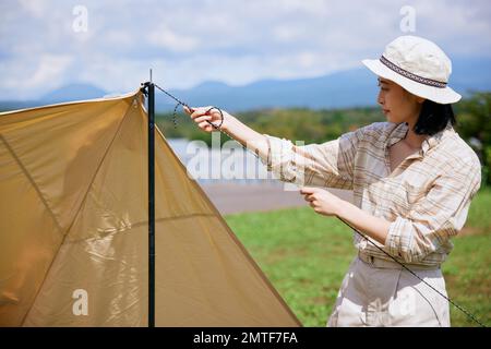 Young Japanese woman at campsite Stock Photo