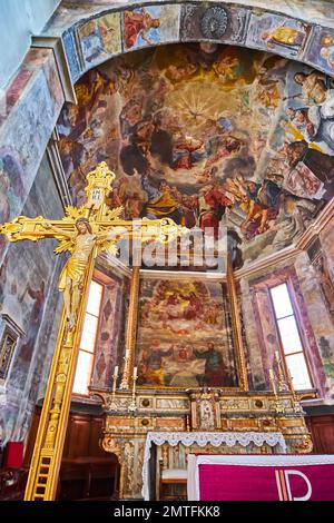 ASCONA, SWITZERLAND - MARCH 28, 2022: St Peter and St Paul Church frescoed altar and apse with golden cross in the foreground,  on March 28 in Ascona Stock Photo
