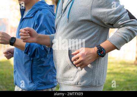 Two elderly men wear sports watches in running Stock Photo