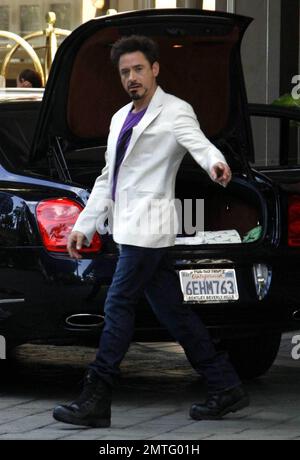 Exclusive!! Robert Downey Jr. leaves the Four Seasons Hotel in Beverly Hills, putting flowers in the trunk and flashing peace sign before getting in his car. 'Iron Man' co-star Terrance Howard left the hotel very shortly afterwards. Los Angeles, CA. 4/3/09. Stock Photo