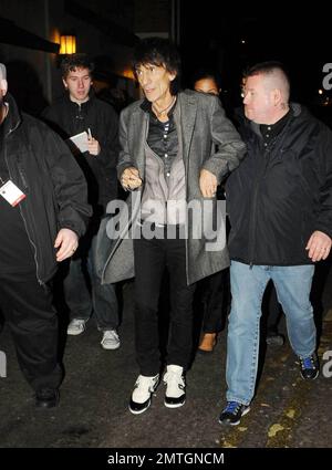 Sucking back on a cigarette and wearing white high-top sneakers The Rolling Stones guitarist Ronnie Wood and girlfriend, Brazilian polo coach Ana Araujo, are flanked by security guards as they arrive at the West End's Ambassadors Theatre for an intimate one-night only concert launching the tribute album Boogie 4 Stu.  The album was created by Ben Waters in memory of the late Ian Stewart (aka Stu), co-founder of The Rolling Stones, who died from a heart attack at the age of 47 in 1985.  Proceeds from the album will go to the British Heart Foundation.  As Ronnie made his way about the outside of Stock Photo