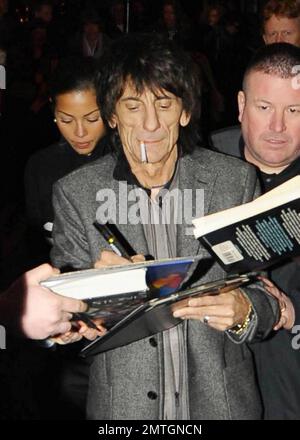 Sucking back on a cigarette and wearing white high-top sneakers The Rolling Stones guitarist Ronnie Wood and girlfriend, Brazilian polo coach Ana Araujo, are flanked by security guards as they arrive at the West End's Ambassadors Theatre for an intimate one-night only concert launching the tribute album Boogie 4 Stu.  The album was created by Ben Waters in memory of the late Ian Stewart (aka Stu), co-founder of The Rolling Stones, who died from a heart attack at the age of 47 in 1985.  Proceeds from the album will go to the British Heart Foundation.  As Ronnie made his way about the outside of Stock Photo