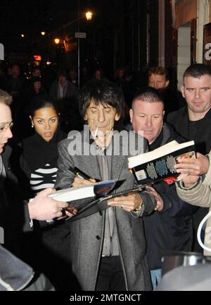 Sucking back on a cigarette and wearing white high-top sneakers The Rolling Stones guitarist Ronnie Wood and girlfriend, Brazilian polo coach Ana Araujo, are flanked by security guards as they arrive at the West End's Ambassadors Theatre for an intimate one-night only concert launching the tribute album Boogie 4 Stu.  The album was created by Ben Waters in memory of the late Ian Stewart (aka Stu), co-founder of The Rolling Stones, who died from a heart attack at the age of 47 in 1985.  Proceeds from the album will go to the British Heart Foundation.  As Ronnie made his way about the outside of Stock Photo