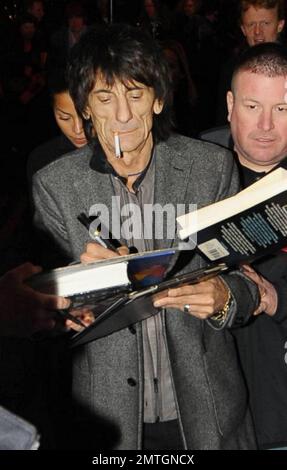 Sucking back on a cigarette and wearing white high-top sneakers The Rolling Stones guitarist Ronnie Wood and girlfriend, Brazilian polo coach Ana Araujo, are flanked by security guards as they arrive at the West End's Ambassadors Theatre for an intimate one-night only concert launching the tribute album Boogie 4 Stu.  The album was created by Ben Waters in memory of the late Ian Stewart (aka Stu), co-founder of The Rolling Stones, who died from a heart attack at the age of 47 in 1985.  Proceeds from the album will go to the British Heart Foundation.  As Ronnie made his way about the outside of Stock Photo