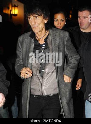 Sucking back on a cigarette and wearing white high-top sneakers The Rolling Stones guitarist Ronnie Wood and girlfriend, Brazilian polo coach Ana Araujo, are flanked by security guards as they arrive at the West End's Ambassadors Theatre for an intimate one-night only concert launching the tribute album Boogie 4 Stu.  The album was created by Ben Waters in memory of the late Ian Stewart (aka Stu), co-founder of The Rolling Stones, who died from a heart attack at the age of 47 in 1985.  Proceeds from the album will go to the British Heart Foundation.  As Ronnie made his way about the outside of Stock Photo