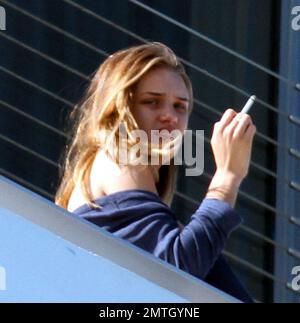 Rosie Huntington-Whiteley chats with pals and smokes a cigarette outside  her hotel in South Beach. The model is in town with her beau, Jason Statham,  to celebrate the new years at a