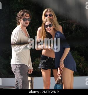 Rosie Huntington-Whiteley chats with pals and smokes a cigarette outside  her hotel in South Beach. The model is in town with her beau, Jason  Statham, to celebrate the new years at a